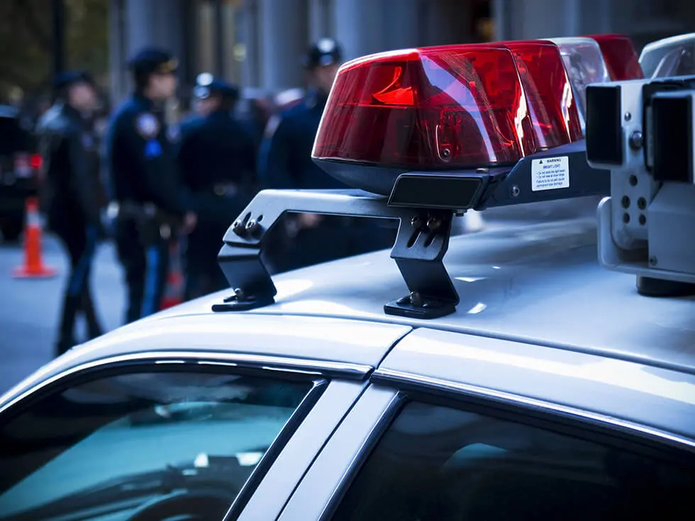 Police car lights close up. A group of policemen on the background